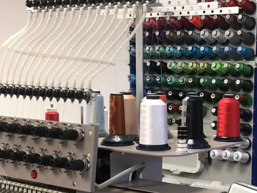 Stickkopf mit Nadeln und Garnkonen an der Stickmaschine in der Werkstatt