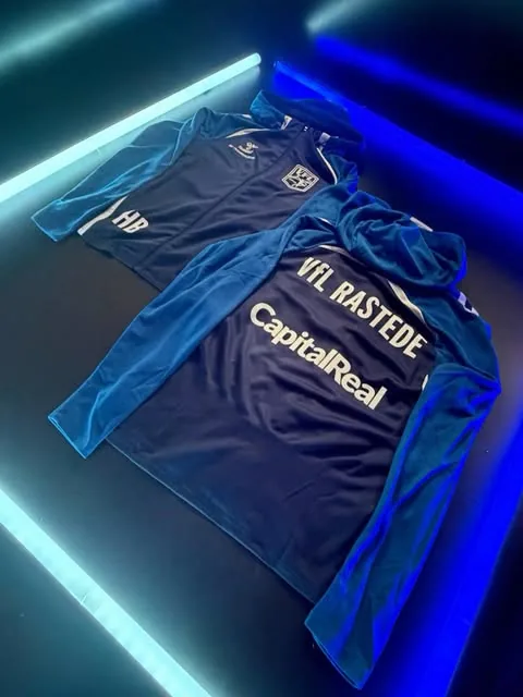 Dunkelblaue Kapuzenjacke des VfL Rastede mit Sponsorendruck CapitalReal