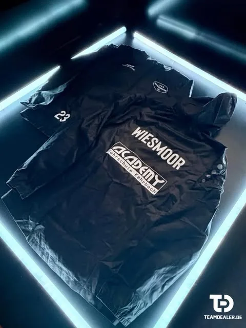 Schwarze Vereinsjacke mit Aufdruck Wiesmoor, Sponsor Academy Fahrschule Kehrbach und Nummer 23